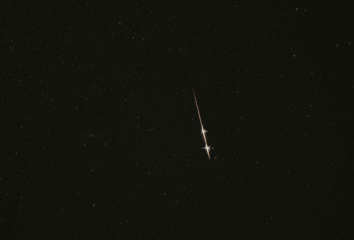 Colored pencil drawing of a gold meteor streaking downward through a dark and dimly starry sky
