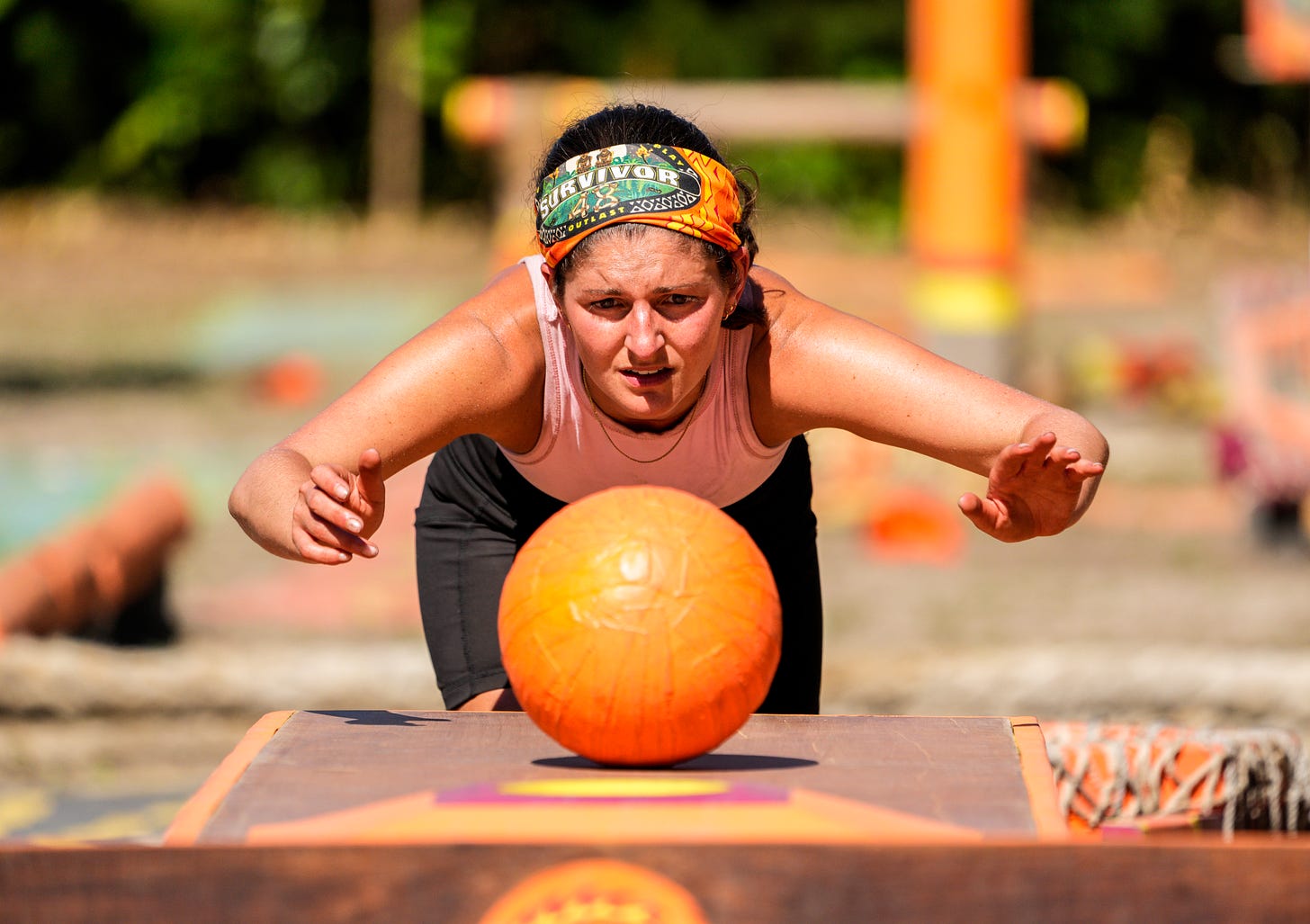 Bianca, deep in concentration, rolls a ball down a game table.