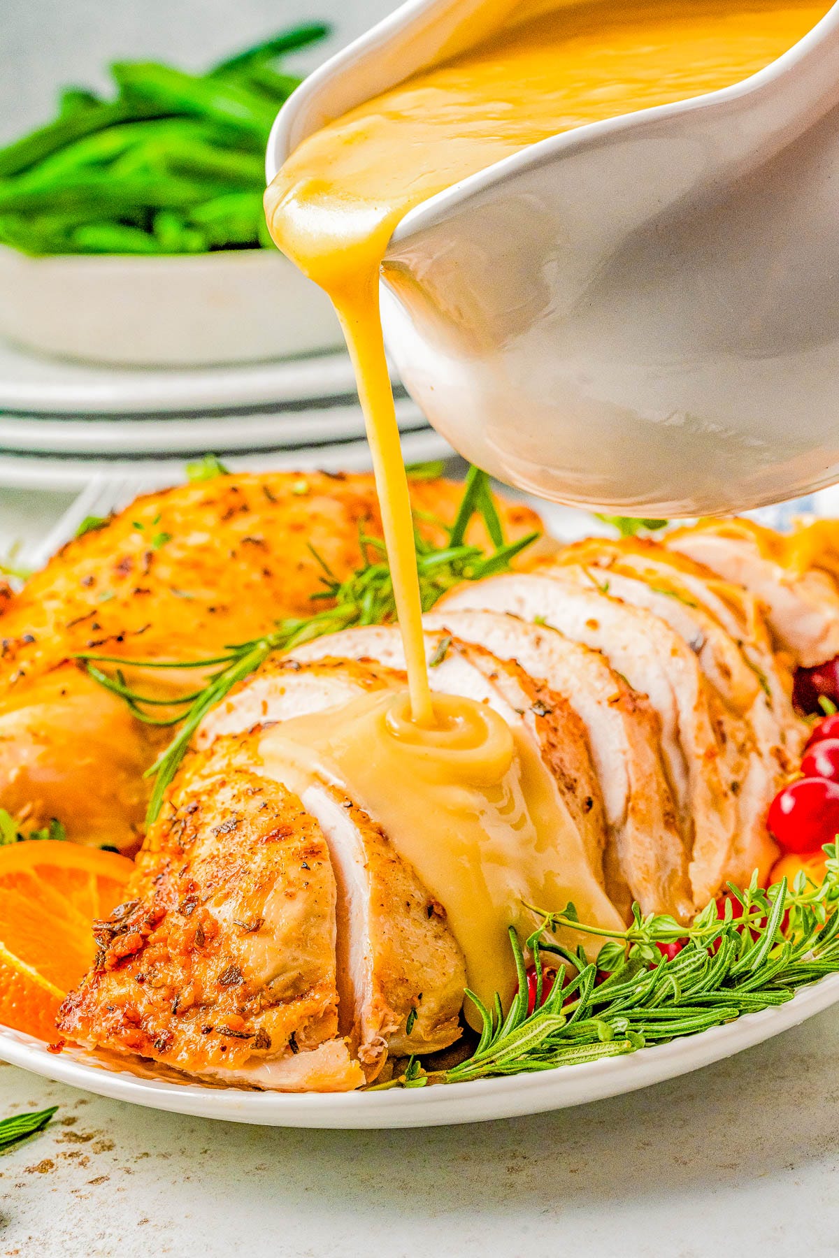 Gravy being poured over a sliced bone-in slow cooker turkey breast. 