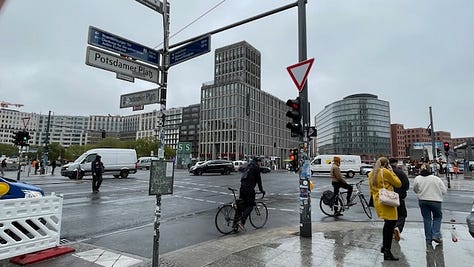 Two images of the busy intersection of Potsdamer Platz in November 2024. One image of the remaining slabs of the Berlin Wall at Potsdamer Platz, November 2024