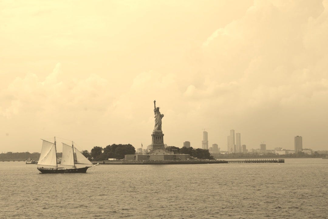 Statue of liberty with sailboat and city skyline