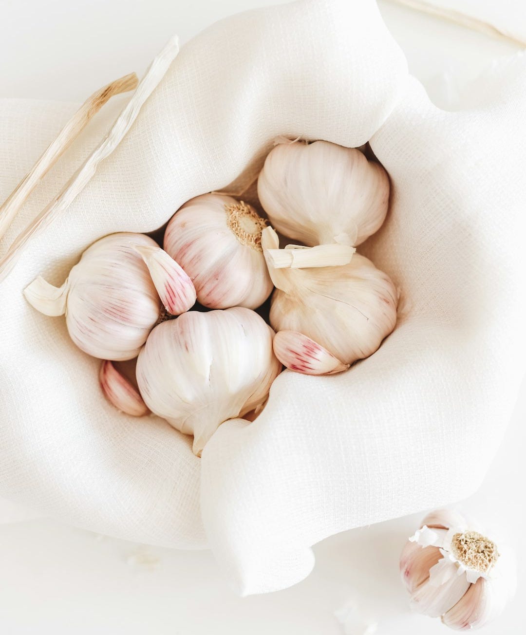 five garlic on white textile five garlic on white textile