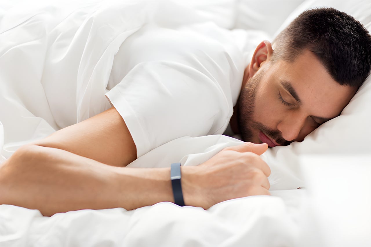 Man sleeping in a bed with soft white bedding