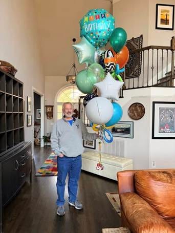 A person standing in a room with balloons

AI-generated content may be incorrect.