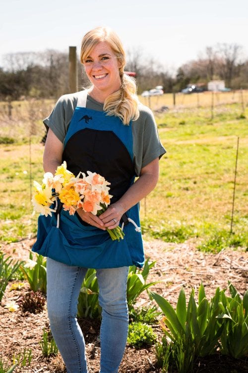 karablueroo 3 Woman wearing a blue Roo Garden Apron holding daffodils.