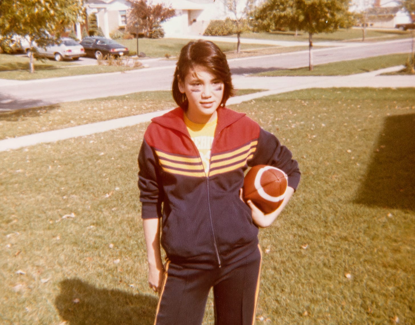 Young Laverne in athletic attire holding a football under her left arm with black paint underneath her eyes. Young Laverne in athletic attire holding a football under her left arm with black paint underneath her eyes.