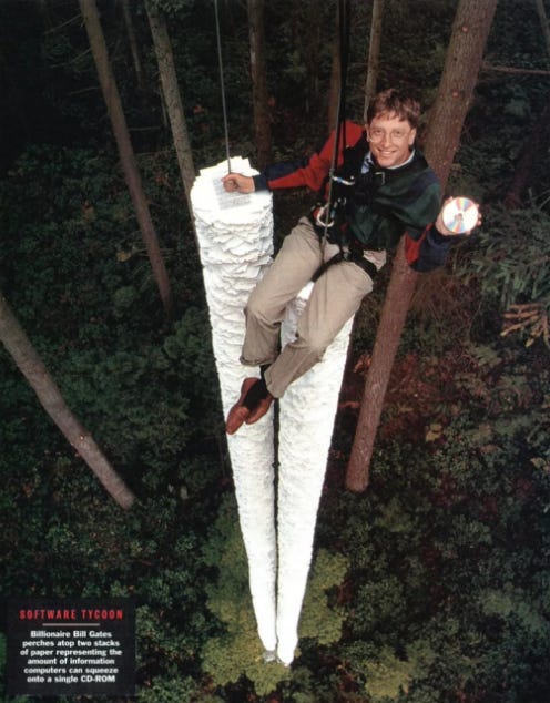 Bill gates atop two stacks of paper representing the amount of information computers can squeeze onto a single CD-ROM