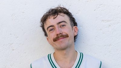 Jack has a moustache and wears a white vest with a green trim.  He has a hoop earring and wears a chain