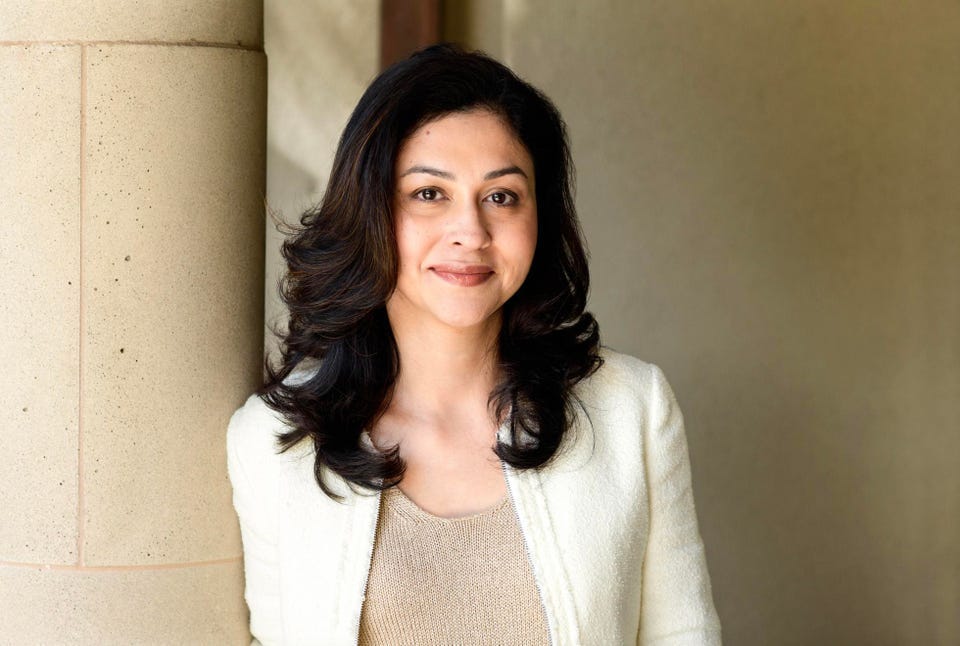 A headshot of Neha Narkhede in front of a tan wall