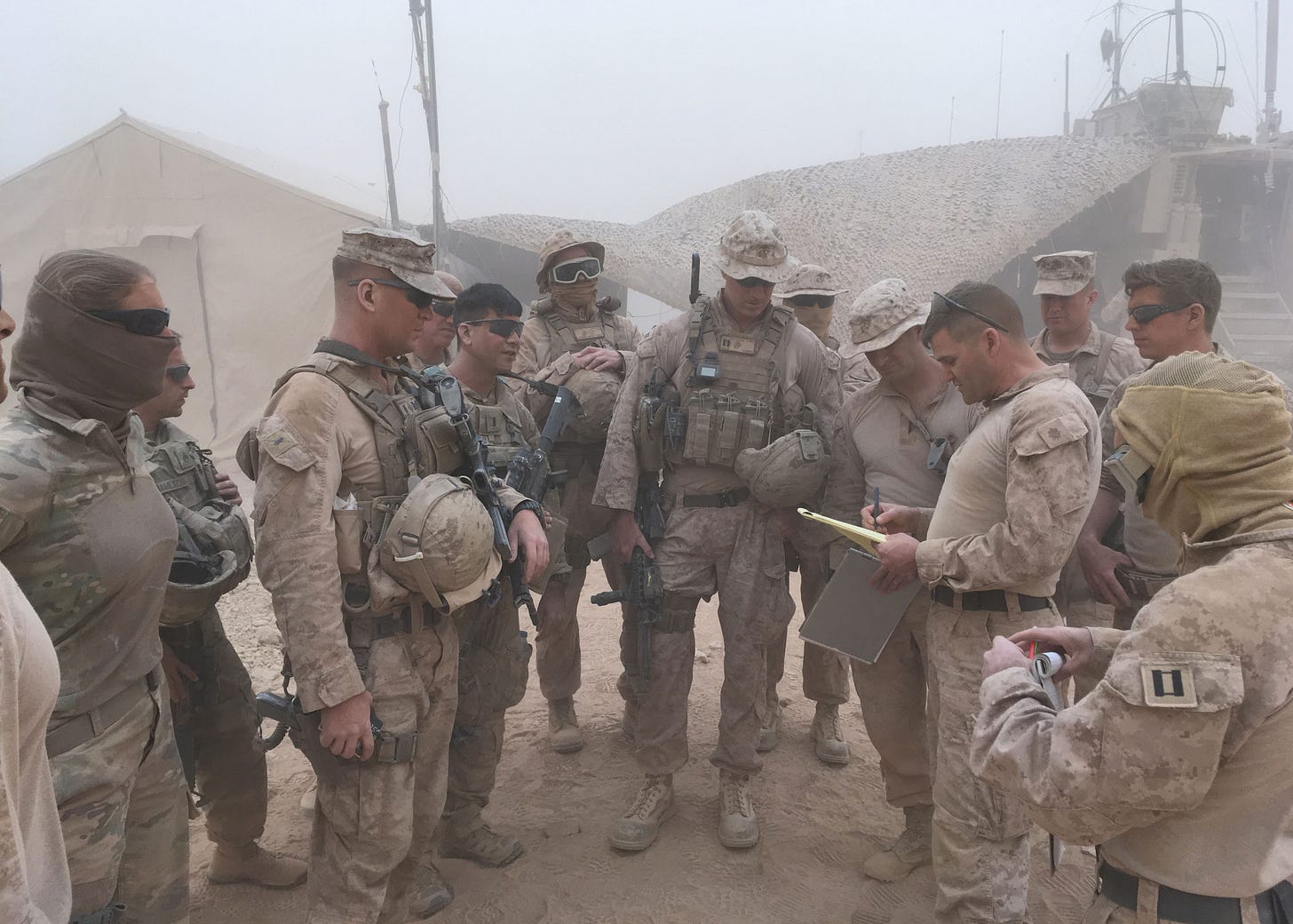 Maj Aaron Awtry briefs Task Force Lion’s site survey team during a dust storm at Tactical Assembly Area Fuhaymi.