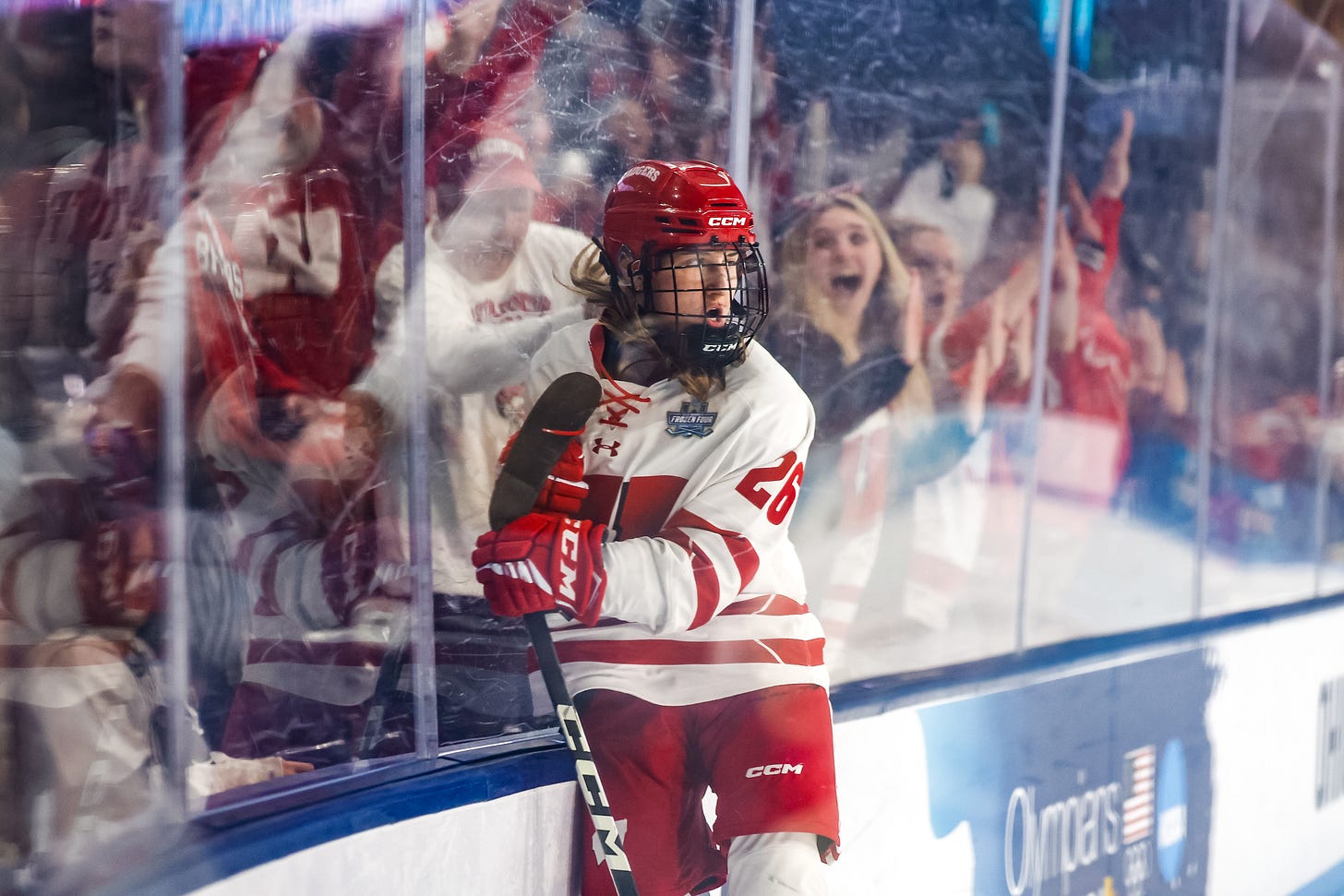 Adéla Šapovalivová jumps into the glass with several Wisconsin Badgers fans behind her Adéla Šapovalivová jumps into the glass with several Wisconsin Badgers fans behind her
