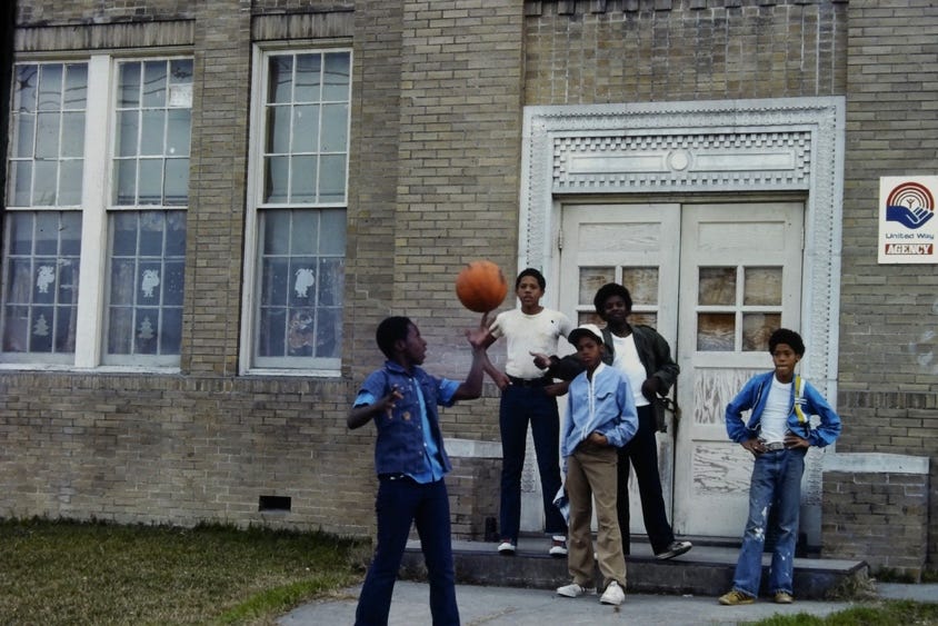 A group of people standing outside a building with a basketball

Description automatically generated with low confidence