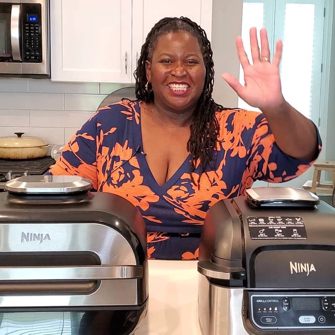 Demetra Overton standing in her kitchen smiling with her Ninja Foodi