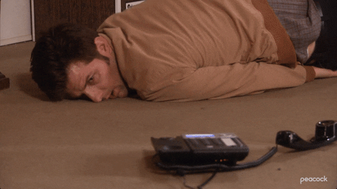 gif from parks and rec of ben sick and rolling on the floor