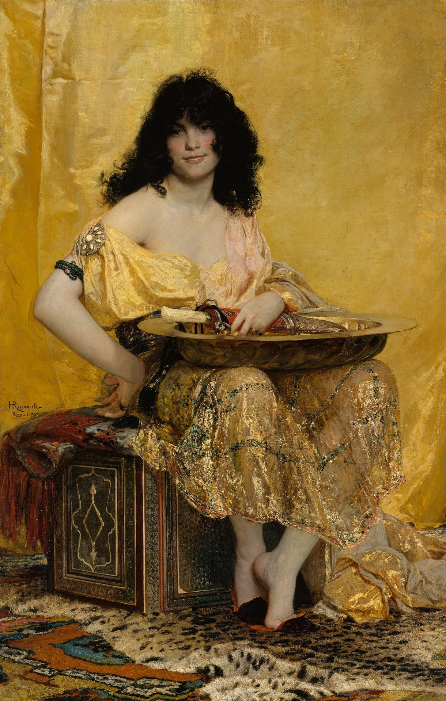 A young woman with a mass of dark hair sits on a chest in a yellow silk gown, smiling at the viewer, with a brass dish and a knife resting on her lap.