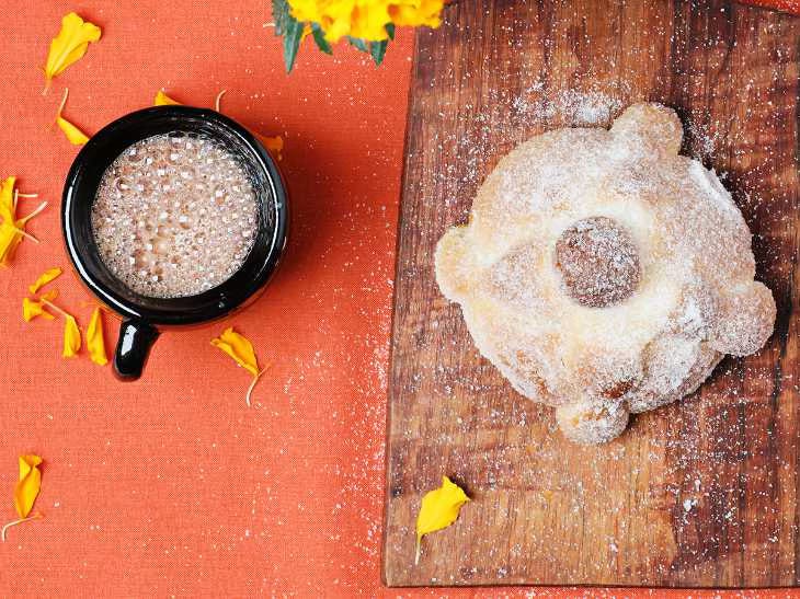 Loaf of pan de muerto and a cup of hot chocolate