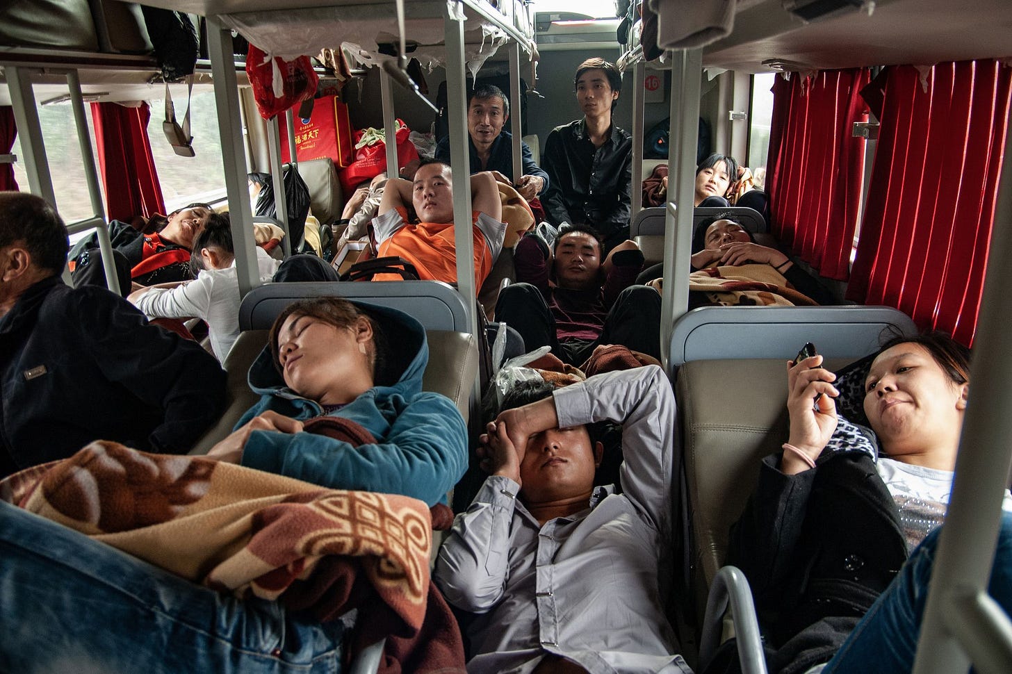 in a factory in China, dozens of people in identical blue overcoats sit on plastic stools working at an assembly line in a factory in China, dozens of people in identical blue overcoats sit on plastic stools working at an assembly line