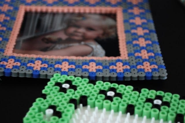 This may contain: a photo frame made out of legos with a green and blue design on it This may contain: a photo frame made out of legos with a green and blue design on it