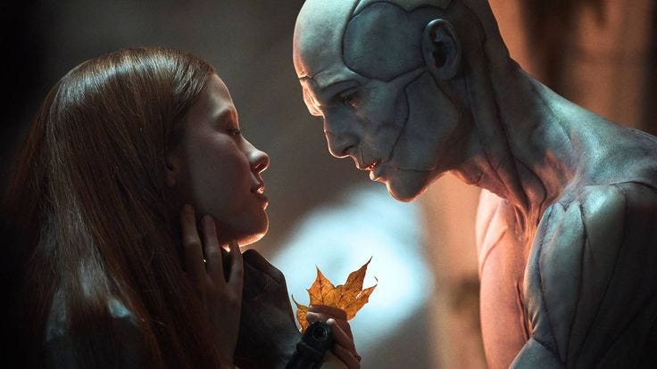 This may contain: two people standing next to each other with one holding a leaf in front of the other