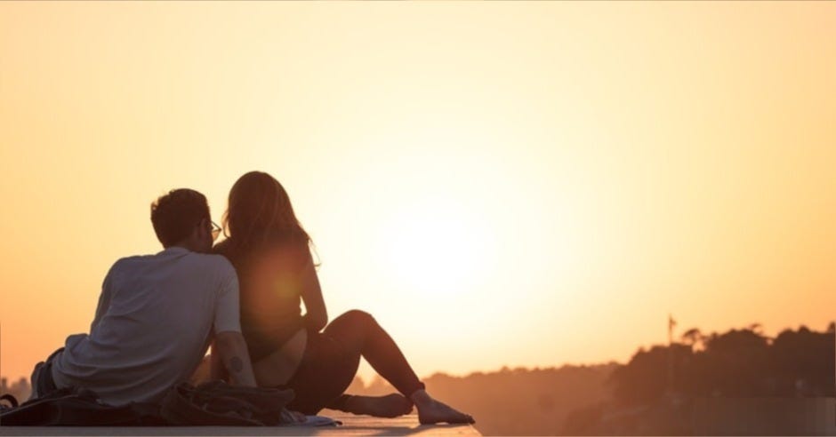 couple sitting near trees during golden hour