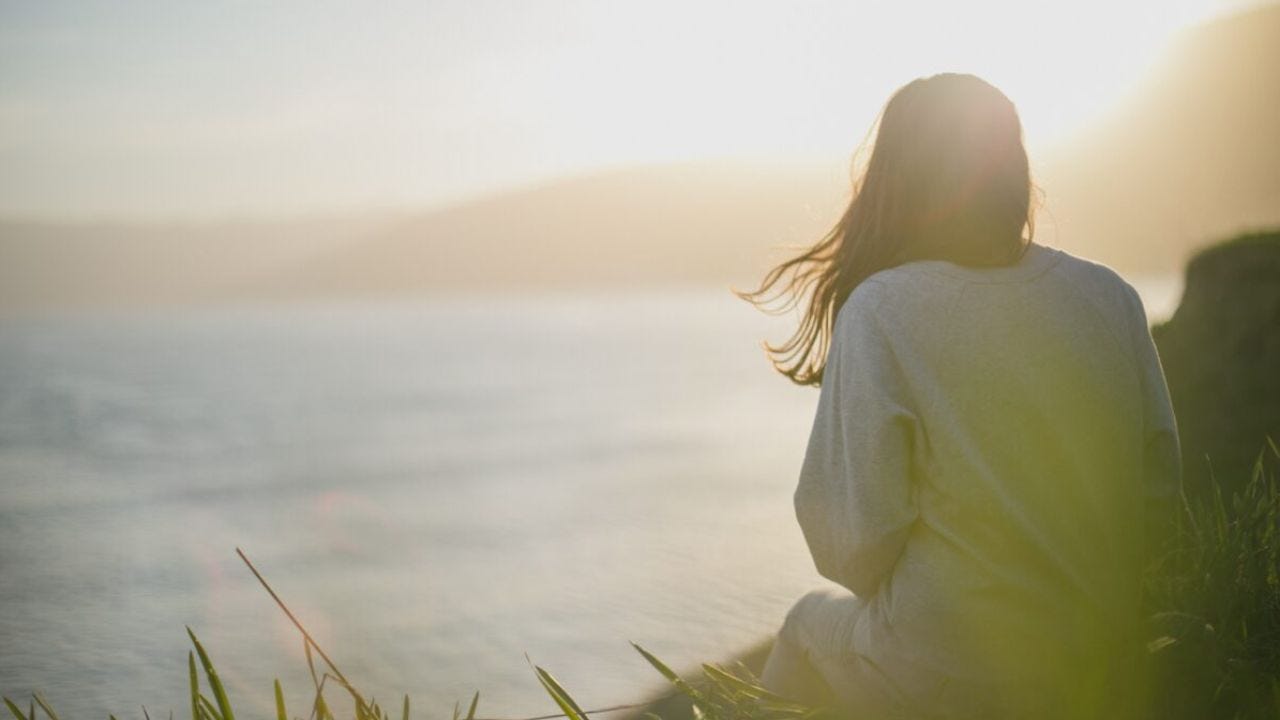woman looking at lake or ocean woman looking at lake or ocean