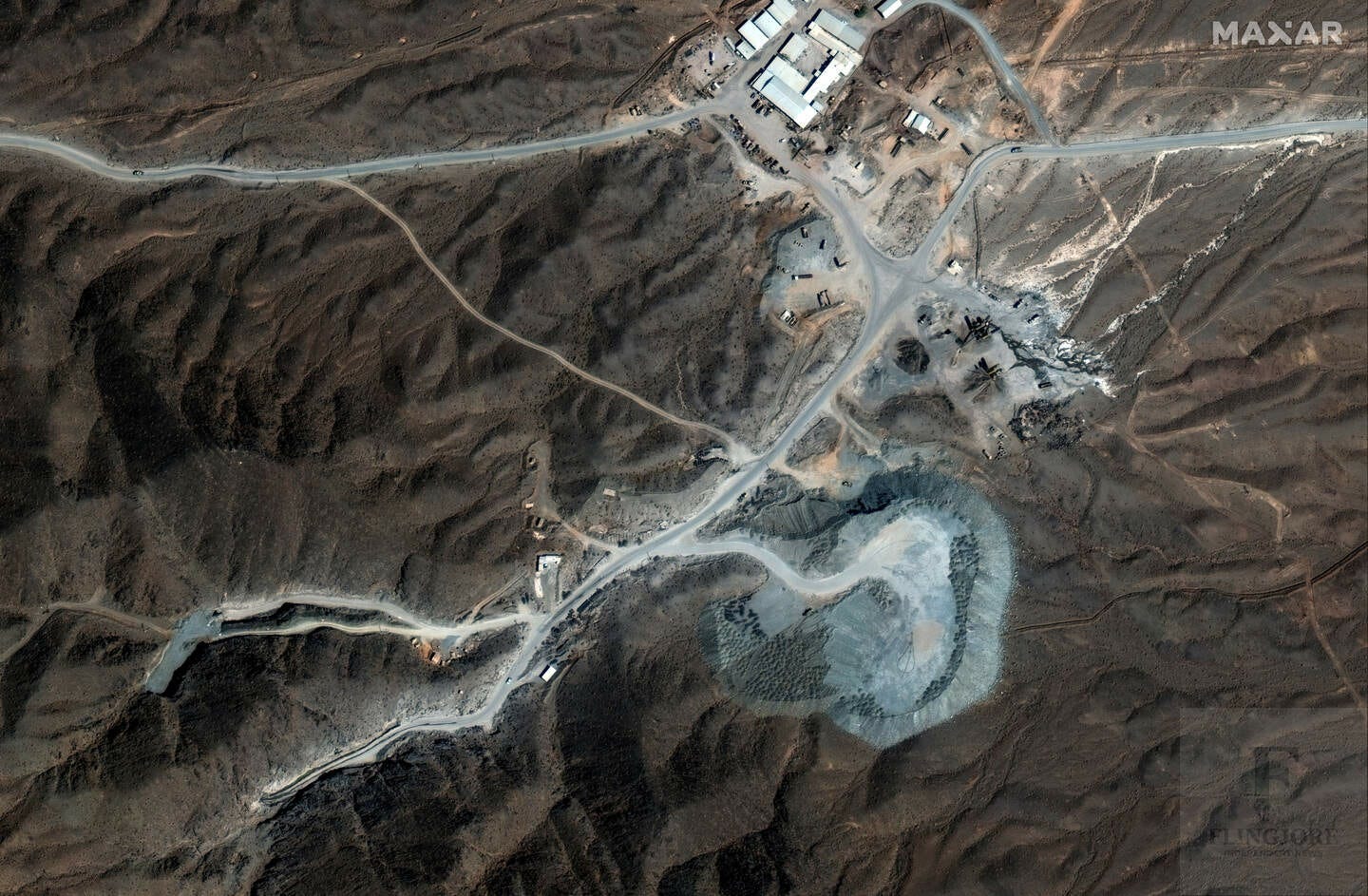 Satellite view of the Natanz nuclear facility in central Iran, showing roads, infrastructure, and excavated areas built into arid, mountainous terrain.