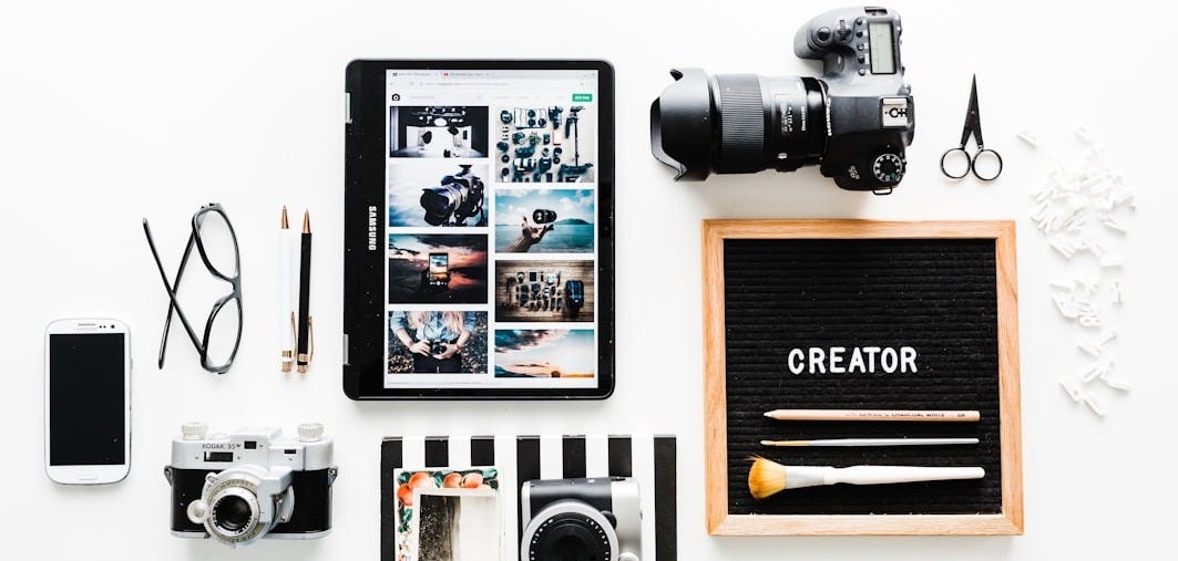 flat view of cameras beside computer tablet and smartphone