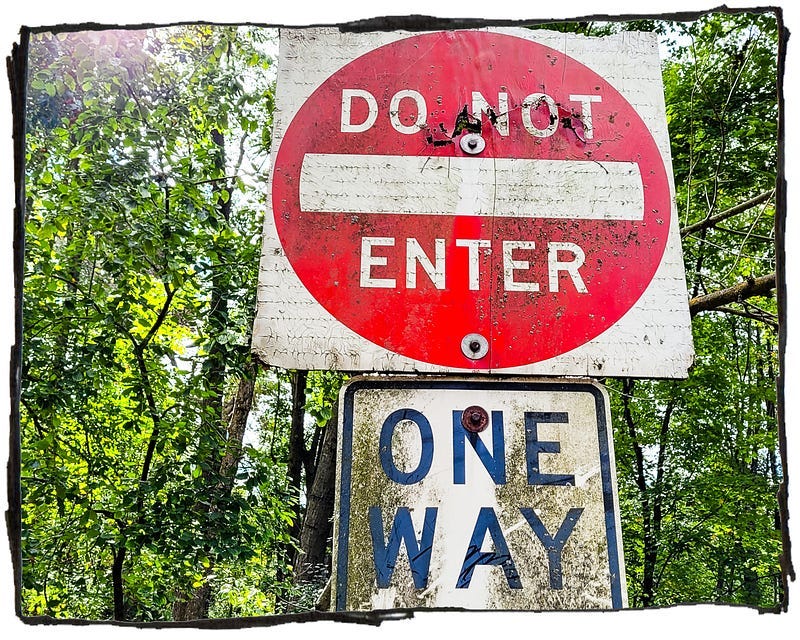 Photo of a “Do not enter” sign out in the woods. Photo of a “Do not enter” sign out in the woods.