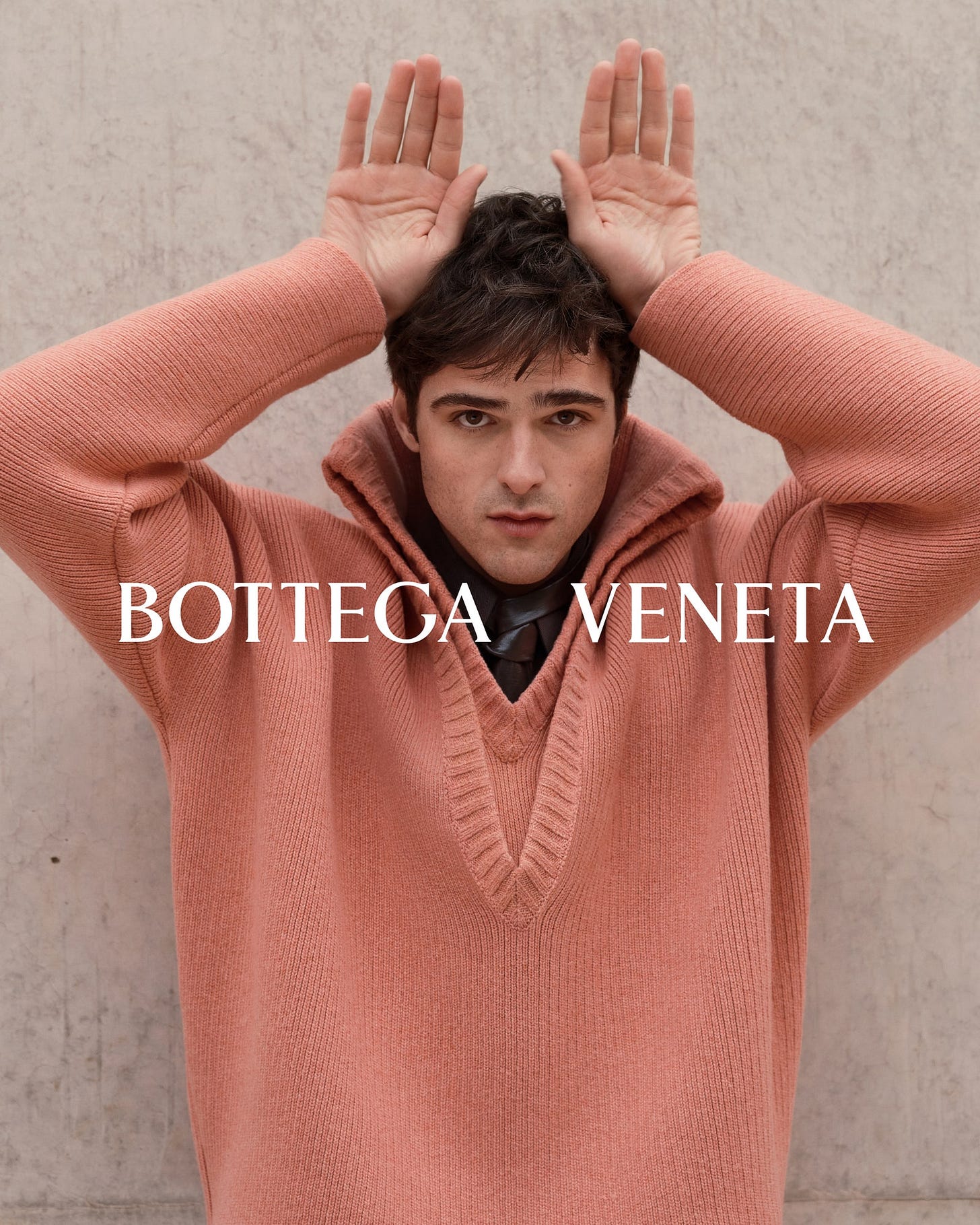 Image may contain Clothing Knitwear Sweater Hoodie Sweatshirt Person Accessories Formal Wear Tie Head and Face