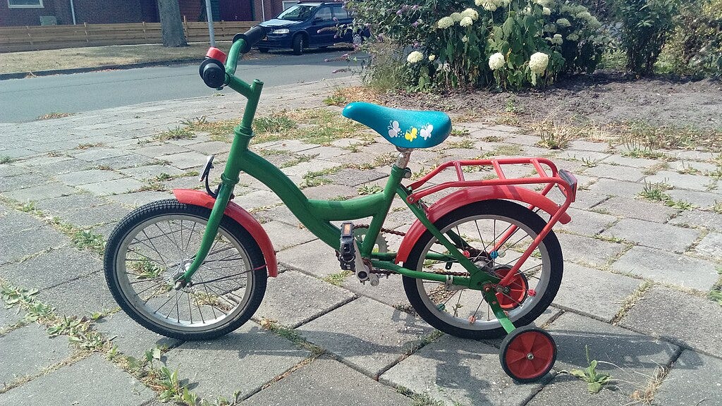 A child's multicolored bicycle with training wheels.