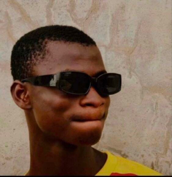 This may contain: a young man wearing sunglasses and looking off to the side in front of a wall