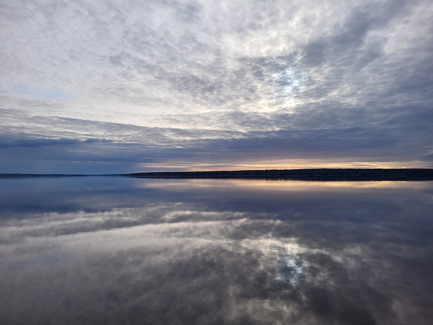 a sunrise over a clear lake