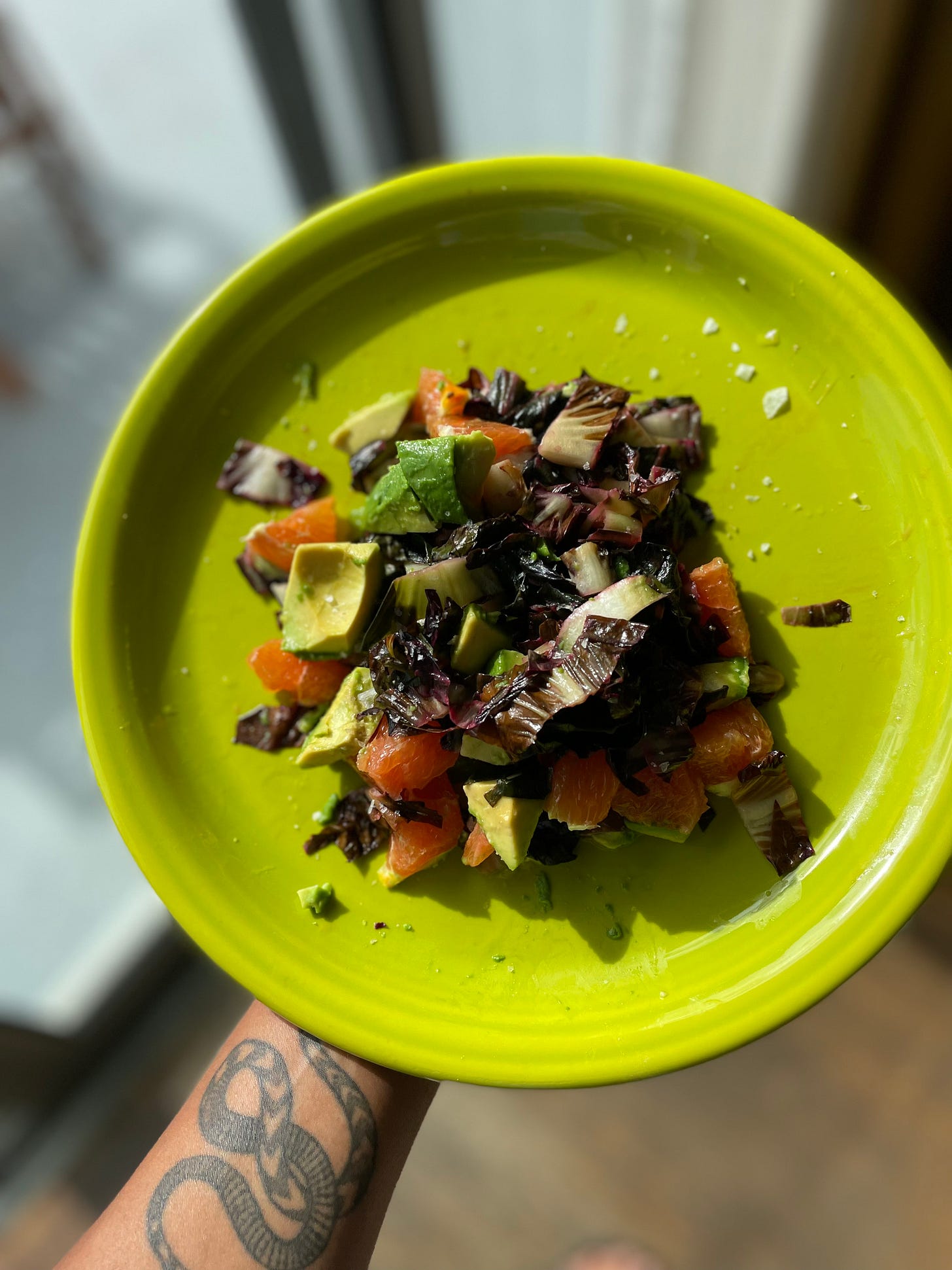 a photo of my favorite salad: a mix of dark greens, cubed avocado and cara cara