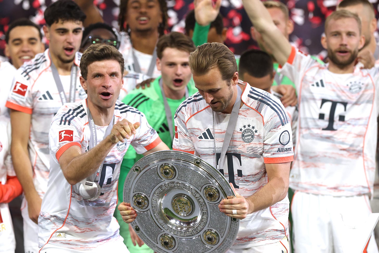 Harry Kane looks at the Bundesliga trophy he's holding in his hands.