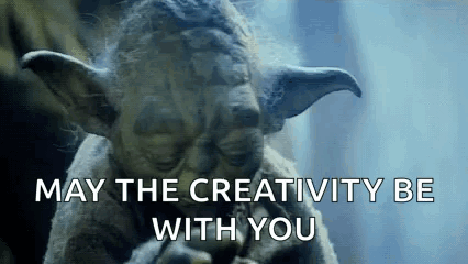a close up of a statue of yoda with the words `` may the creativity be with you '' written on it .