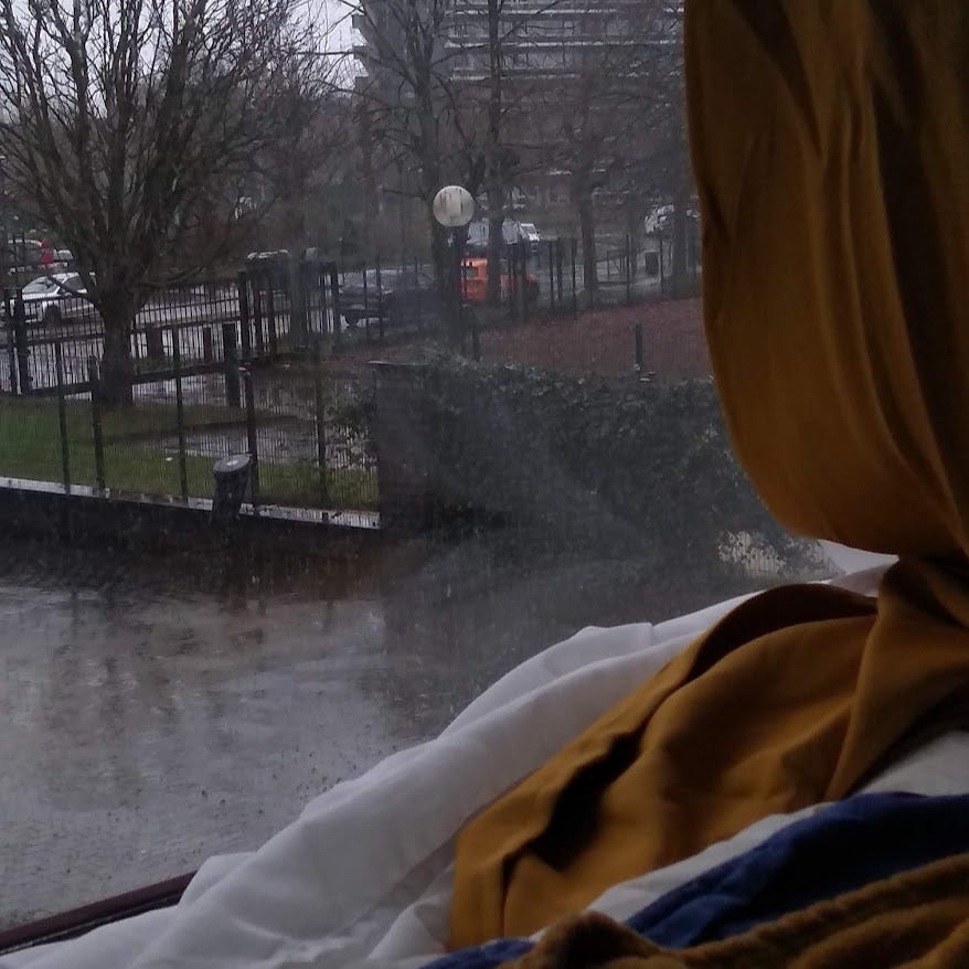 View from a bedroom window to a rainy street outside in winter in Belgium