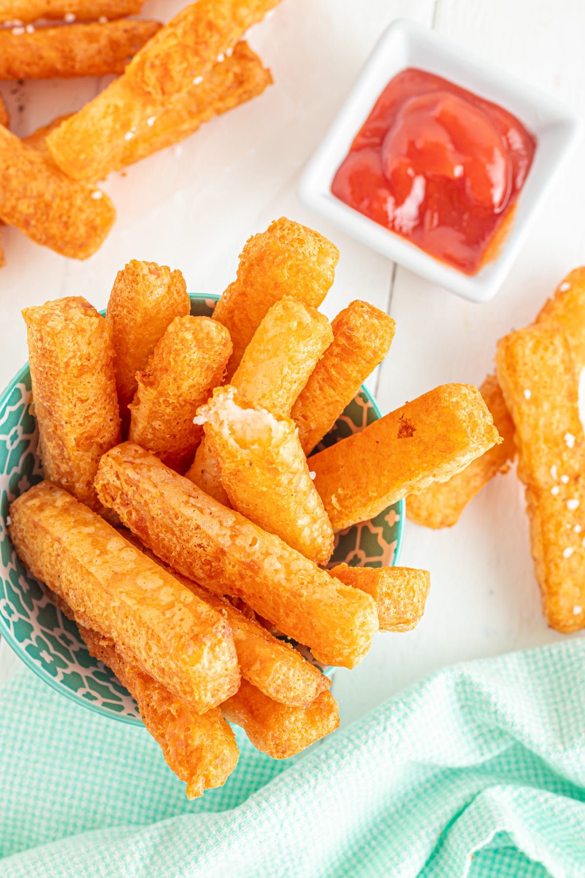 Mashed potato fries on table with ketchup.