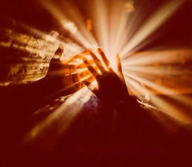 This may contain: a person holding their hands up in the air with beams of light coming from them