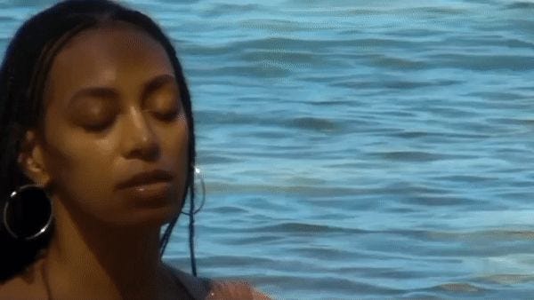 This may contain: a woman in the water with her eyes closed