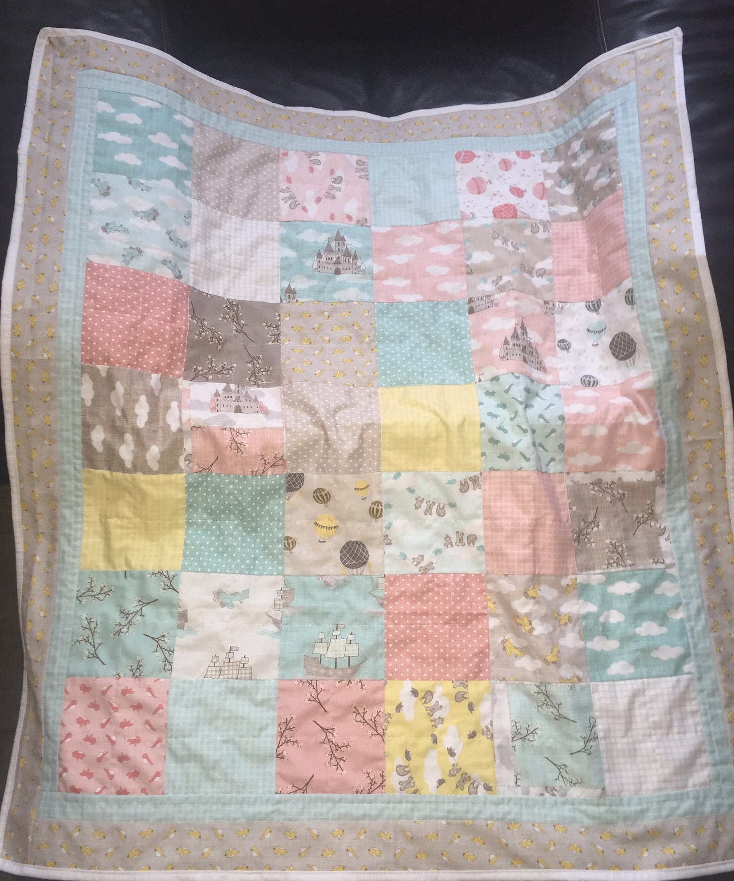 A baby quilt with yellow, pink and teal, along with neutral taupes. Featuring branches, clouds, hot air balloons castles and ships. A baby quilt with yellow, pink and teal, along with neutral taupes. Featuring branches, clouds, hot air balloons castles and ships.