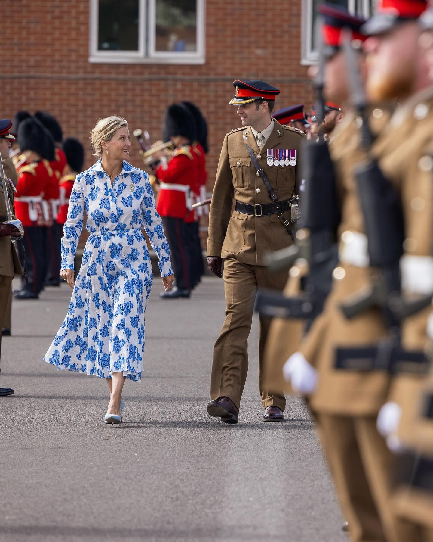 Duchess Sophie, wearing blue floral dress, and inspecting military parade