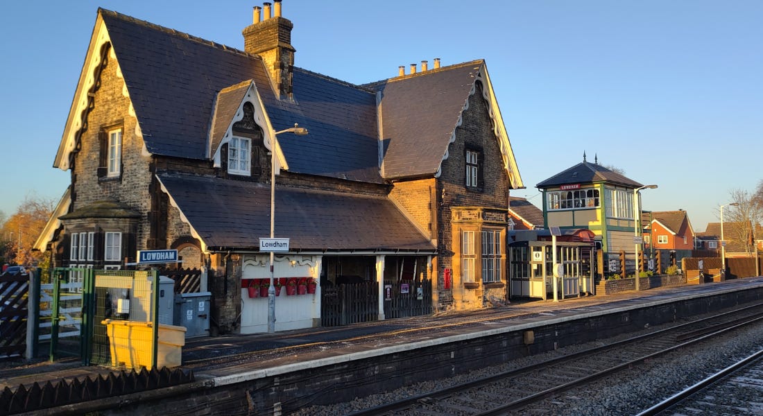 A train station - Lowdham - with railway tracks and a large house by them A train station - Lowdham - with railway tracks and a large house by them