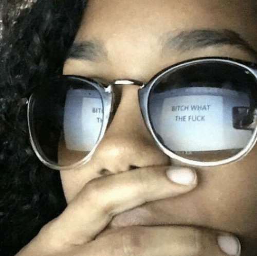 A woman looking at the computer screen that reads "BITCH WHAT THE FUCK"