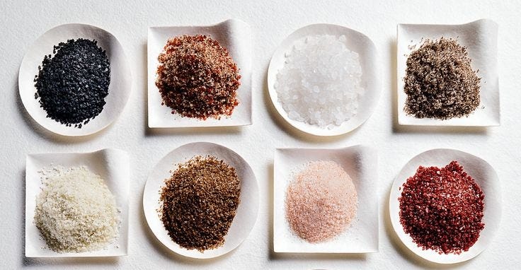 8 different colored salts on plates
