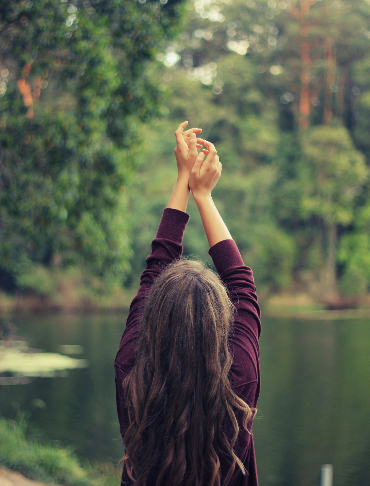 Woman meditating in in lake. Jessika Fruchter, LMFT, offerings therapy for women in perimenopause in California.