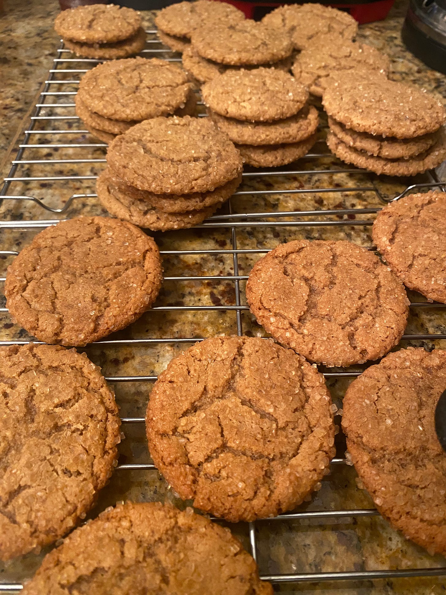 A cooling rack with peanut butter cookies, flat with crackled tops, coated in large sugar granules.