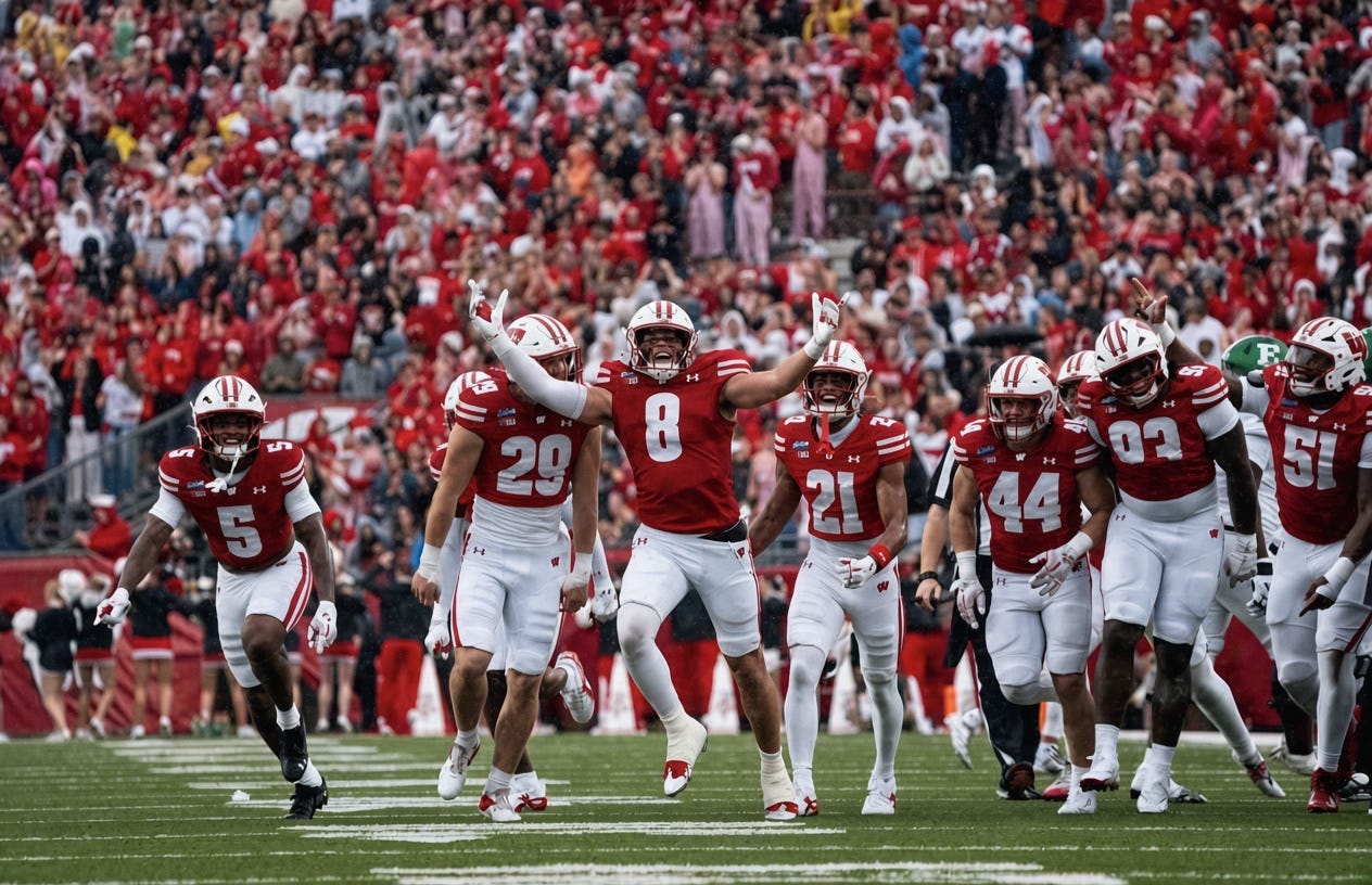 Wisconsin Badgers defenders celebrate together on the field at Camp Randall Stadium.