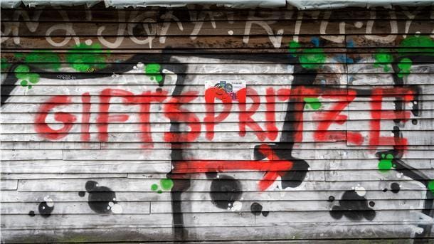 In der Nähe eines Impfzentrums für die Impfung gegen das Coronavirus ist ein Graffiti mit dem Schriftzug „Giftspritze".