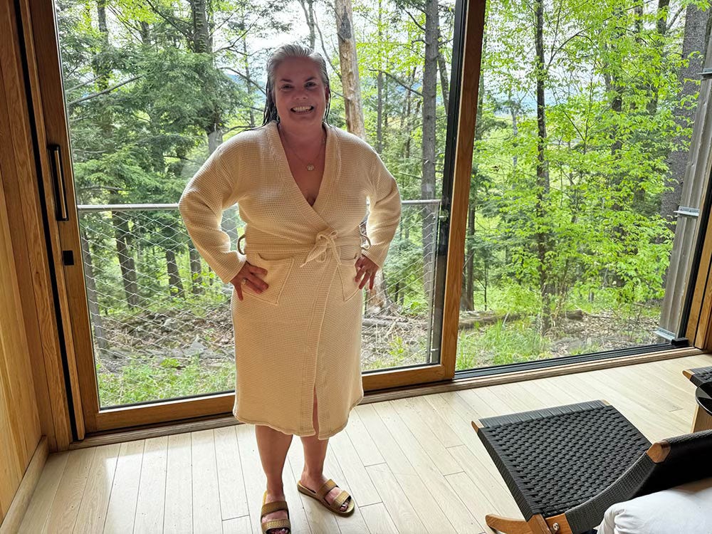Woman modeling robe inside modern cabin Woman modeling robe inside modern cabin