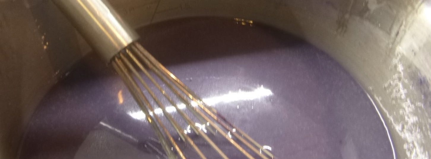 Bowl with whisk and violet soap mixture